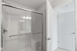 Frameless glass shower enclosure with chrome hardware, integrated shower bench, and subway tile accents - 