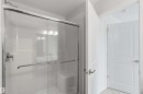Frameless glass shower enclosure with chrome hardware, integrated shower bench, and subway tile accents - 5733 Hawthorn Common Sw, Edmonton, AB 