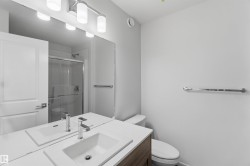 Vanity with an integrated rectangular sink, chrome faucet, and wood-finish cabinetry - 