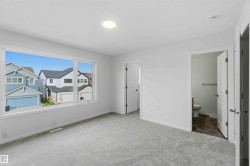 Expansive window with white trim, light gray carpeting, recessed ceiling lighting, and white paneled interior doors - 