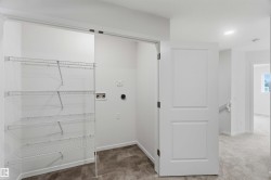 Laundry area featuring wire shelving, utility hookups, and wood-finish flooring - 
