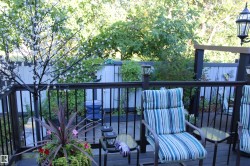 Expansive wooden deck with dark railing and integrated post lighting, offering an outdoor living area - 