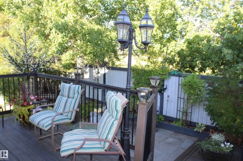 Spacious outdoor deck featuring dark wood-finish flooring, black metal railings, and a double post lamp - 3815 41 Street Nw, Edmonton, AB 