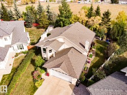 Light-colored stucco exterior with a multi-gabled roof and an attached garage - 