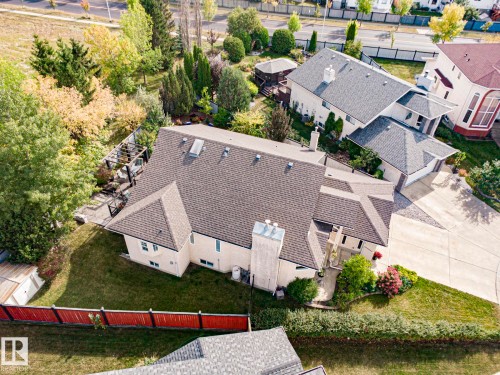 Expansive property featuring a multi-level roofline, extensive paved driveway, established landscaping, private rear patio with a pergola, and a visible adjacent property with a separate gazebo structure - 3815 41 Street Nw, Edmonton, AB 