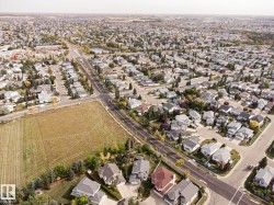 Expansive residential area featuring a central pond, established tree-lined streets, and varied single-family homes - 