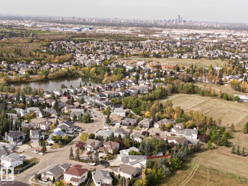 Expansive residential area featuring a central lake, surrounding green spaces, and a distant city skyline - 3815 41 Street Nw, Edmonton, AB 