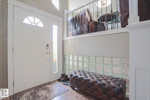 Entryway featuring a white paneled door with an arched transom, a sidelight, and a glass block wall - 3815 41 Street Nw, Edmonton, AB 