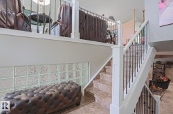 Staircase with tile treads and risers, white newel posts, and black wrought iron balusters - 