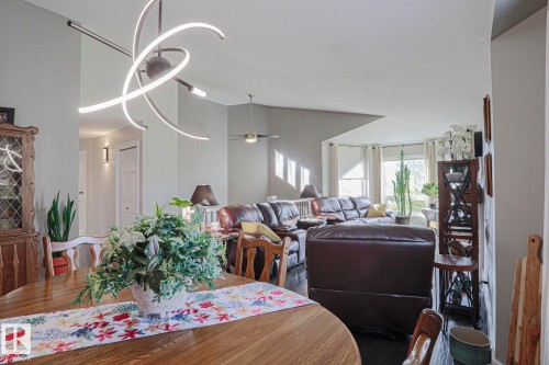 Open concept living area with vaulted ceilings, recessed lighting, and a contemporary linear light fixture Modern updated lighting. - 3815 41 Street Nw, Edmonton, AB 