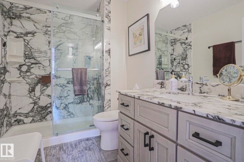Glass-enclosed shower with a white and gray patterned surround - 3815 41 Street Nw, Edmonton, AB 