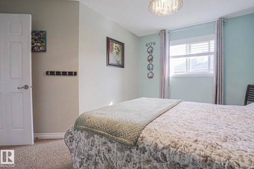 Wall-to-wall carpeting with a white paneled door and window with blinds - 3815 41 Street Nw, Edmonton, AB 