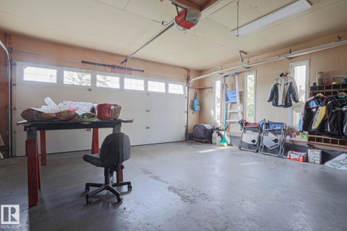 Overhead garage door with transom windows, multiple side windows, and overhead fluorescent lighting - 3815 41 Street Nw, Edmonton, AB 