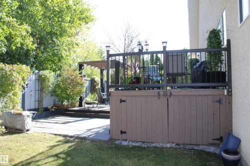 Expansive backyard featuring a manicured lawn, multi-level patio, and a separate deck with metal railings - 3815 41 Street Nw, Edmonton, AB 