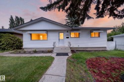 White siding exterior with a pitched roofline, concrete walkway, and a tiered concrete entry - 