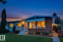 Brick and stucco exterior with multiple awnings, a paved walkway, and a landscaped front yard with a low brick wall - 12835 91 Street Nw, Edmonton, AB 