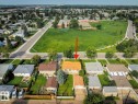 Residential property with a distinct orange-toned roof, front yard with mature tree, and a detached garage - 12835 91 Street Nw, Edmonton, AB 