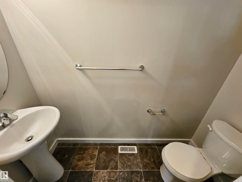 Pedestal sink with chrome faucet, tiled flooring, and a white toilet - #69 903 Crystallina Nera Wy Nw, Edmonton, AB 