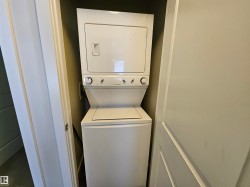 Stacked washer and dryer unit within an alcove - 