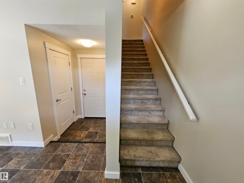 Carpeted staircase with wall-mounted handrail, leading to upper level - #69 903 Crystallina Nera Wy Nw, Edmonton, AB 