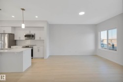 Modern kitchen with stainless steel appliances, white cabinetry, and subway tile backsplash - 