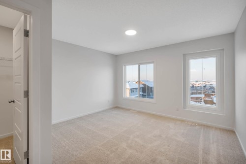 Neutral tone carpeting, multiple windows, and a recessed ceiling light - 5239 - 5245 21A Avenue Sw, Edmonton, AB 