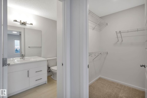 White vanity with integrated sink, chrome faucet, and storage drawers - 5239 - 5245 21A Avenue Sw, Edmonton, AB 