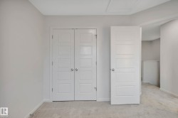 Neutral-toned walls with carpet flooring, featuring a bifold closet door and a paneled interior door - 