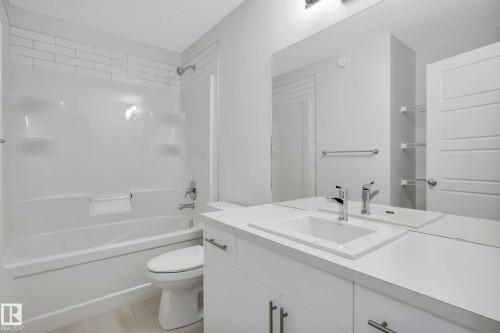 White subway tile shower surround with integrated shelving and chrome fixtures - 5239 - 5245 21A Avenue Sw, Edmonton, AB 