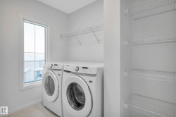 Dedicated laundry area featuring a large window, wire shelving, and wood-finish flooring - 