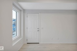 Wood-finish flooring with a white paneled door and large window - 