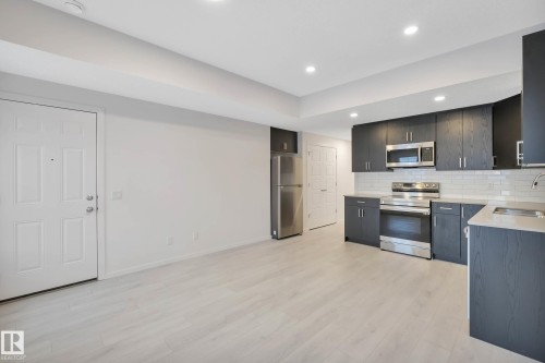 Light wood-finish flooring complements white walls - 5239 - 5245 21A Avenue Sw, Edmonton, AB 