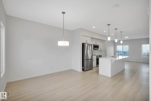 Open concept design with wood-finish flooring, white walls, and abundant natural light - 5239 - 5245 21A Avenue Sw, Edmonton, AB 