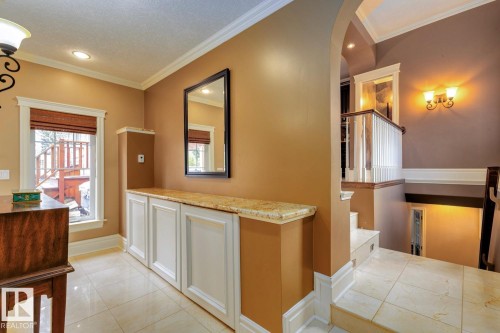 Corridor with ornamental molding, light tile patterned flooring, arched walkways, plenty of natural light, and recessed lighting - 6306 111 Avenue Nw, Edmonton, AB 