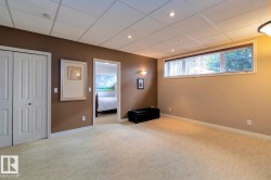 Basement with carpet flooring, a paneled ceiling, and recessed lighting - 