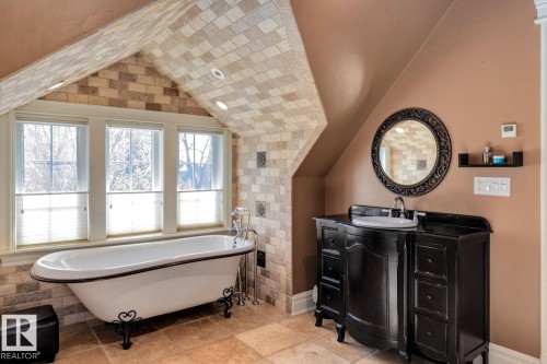 Full bathroom with a freestanding bath, vanity, and lofted ceiling - 6306 111 Avenue Nw, Edmonton, AB 