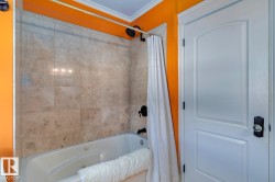 Full bath featuring ornamental molding and a combined bath / shower with jetted tub - 