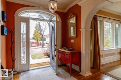 Entrance foyer featuring light wood-style flooring, crown molding, arched walkways, plenty of natural light, and a chandelier - 