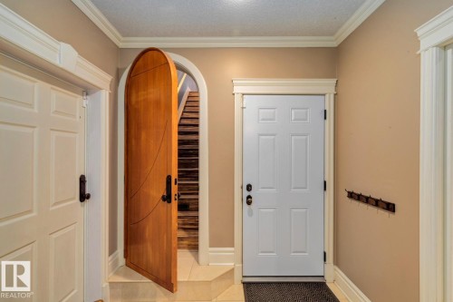 Doorway to outside with crown molding, tile patterned flooring, arched walkways, and a textured ceiling - 6306 111 Avenue Nw, Edmonton, AB 