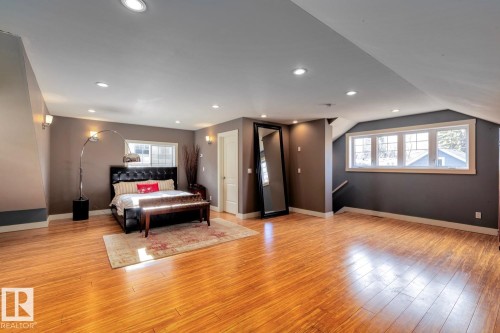 Bedroom with light wood finished floors, recessed lighting, and lofted ceiling - 6306 111 Avenue Nw, Edmonton, AB 