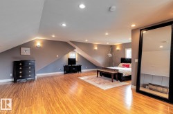 Bedroom with light wood finished floors, recessed lighting, and vaulted ceiling - 