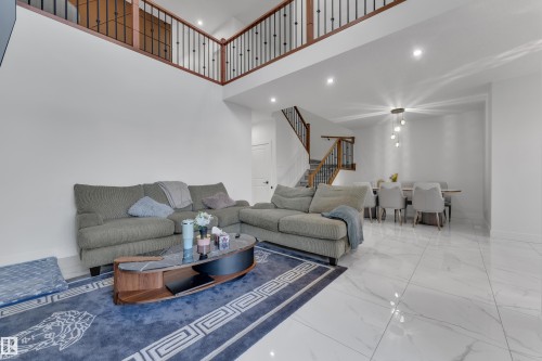 Two-story living area with high ceilings, recessed lighting, and a second-story overlook featuring wood-finish railings - 6502 42 Ave, Beaumont, AB 