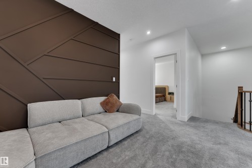Accent wall with geometric paneling, recessed lighting, and carpet flooring - 6502 42 Ave, Beaumont, AB 
