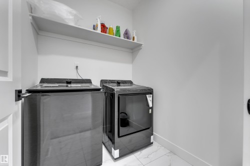 Laundry area featuring a wall-mounted shelf and tile flooring - 6502 42 Ave, Beaumont, AB 