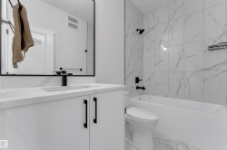 White vanity with matte black hardware, integrated sink, and wall-mounted faucet - 