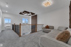 Open landing featuring carpet flooring and a wood and wrought iron railing - 