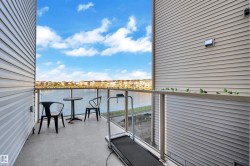 Balcony with glass railing, concrete flooring, and water frontage - 