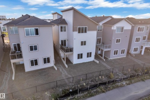 Modern multi-level residences featuring light-toned siding and dark shingle roofs - 6502 42 Ave, Beaumont, AB 