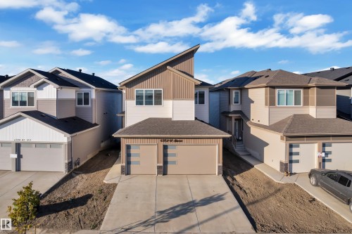 Contemporary facade featuring multi-toned siding, a distinct roofline, and an attached two-car garage with modern paneling - 6502 42 Ave, Beaumont, AB 