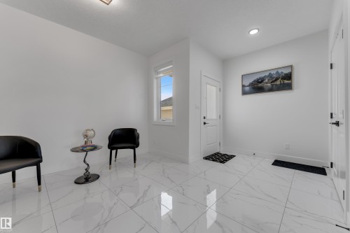 White tile flooring with a marble-like pattern, white walls, and a window with natural light - 6502 42 Ave, Beaumont, AB 